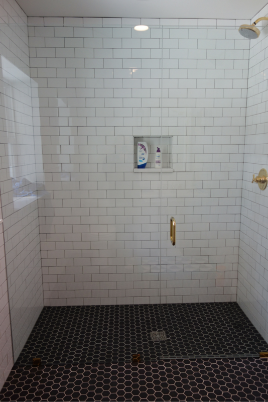 Roll in curbless shower with a frameless glass shower door 