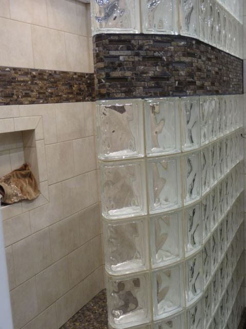 Close up of decorative tile border in a curved glass block shower wall