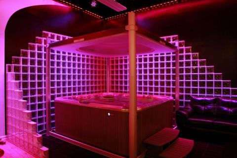 Glass block wall illuminated with Chauvet LED lighting around Jacuzzi tub in a live work space