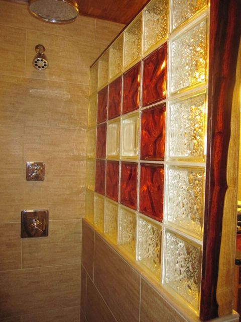 Inside view of shower with custom glass block wall and decorative paduk wood trim in a Texas remodel