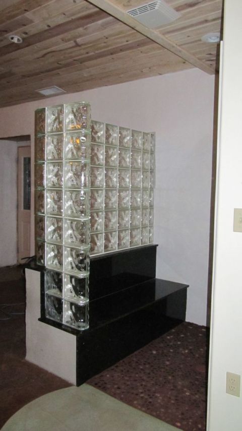 Glass block step down shower wall on a deck and bench seat