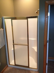 Before - small fiberglass shower with a skinny entry through a sliding glass door