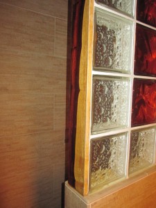 Close up of cocobolo trim surrounding glass block shower wall 