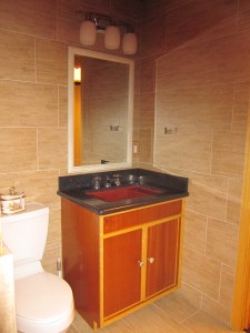 Custom vanity with ribbon wood and beech trim and a Kohler Ledges sink 