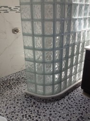 Zero threshold shower with a curved glass block wall 