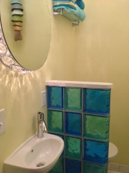 Small partition wall in a half bathroom using colored glass blocks 