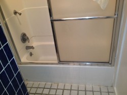 Old Fiberglass tub shower unit with framed glass doors before new shower installation 