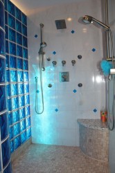 Blue light streaming through sapphire colored glass block shower wall 