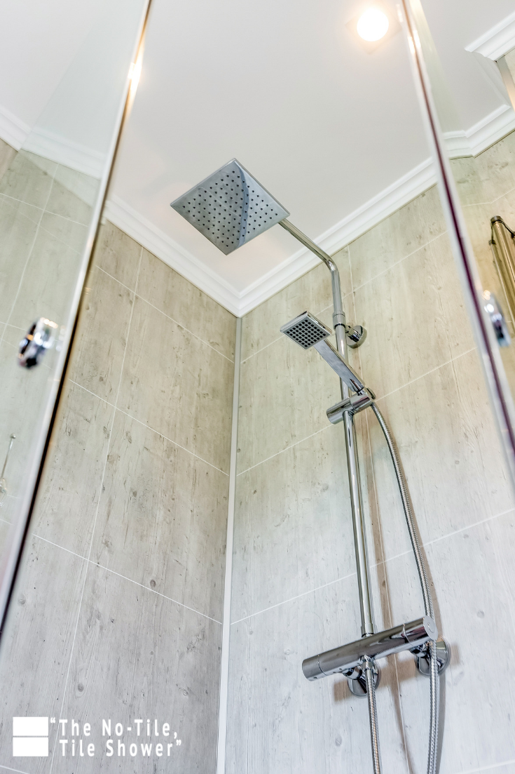 Rain shower head with cracked cement pattern laminated wall panels | Innovate Building Solutions