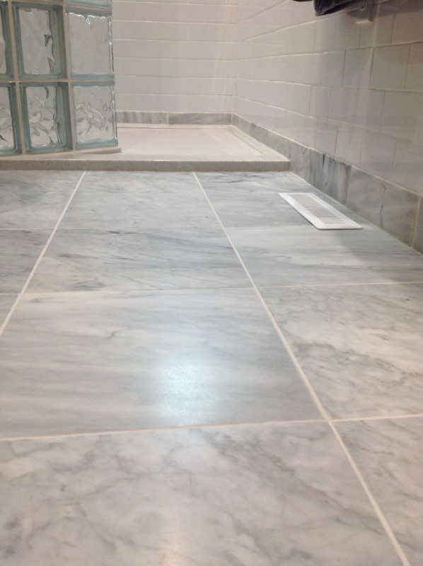 Low profile curb in a solid surface shower pan with glass blocks 