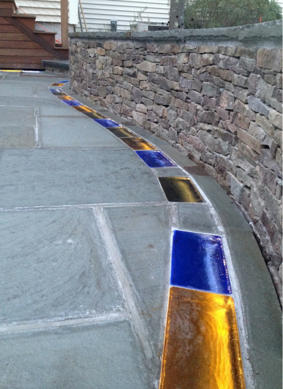 Solid colored glass brick pavers with LED lighting in a bluestone patio in Connecticut