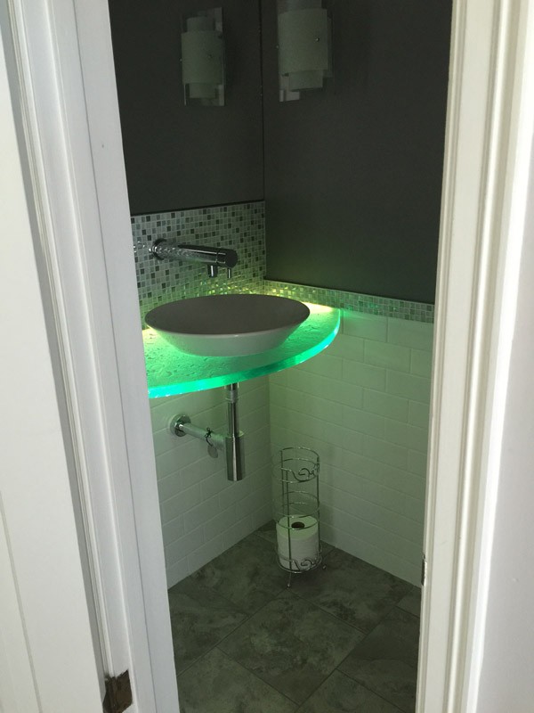 glass countertop in a bathroom vanity with LED lighting