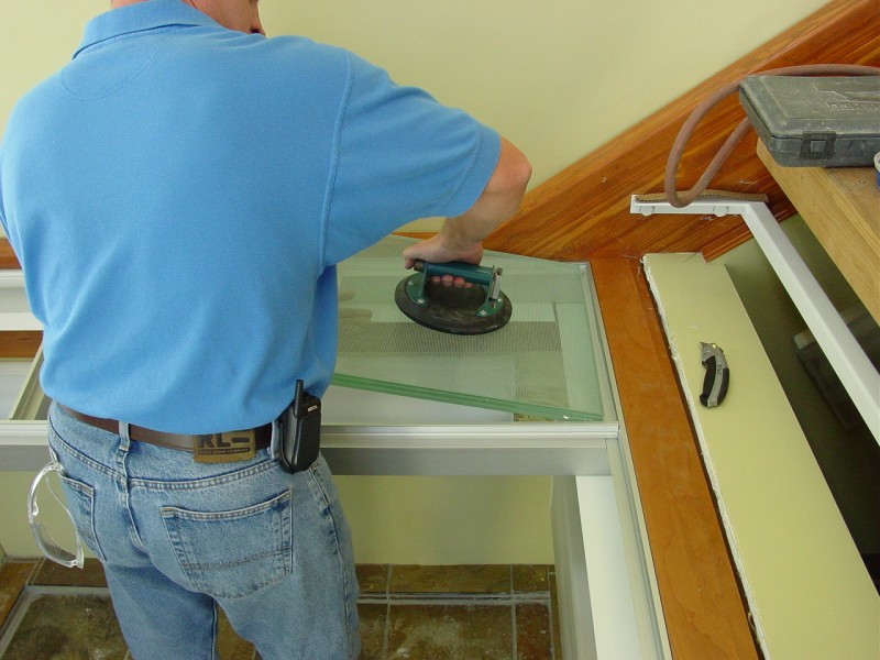 Aluminum framing system surrounding glass floor panels during installation 