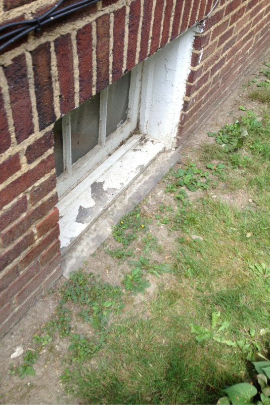 Deteriorated wood framed basement window frame 