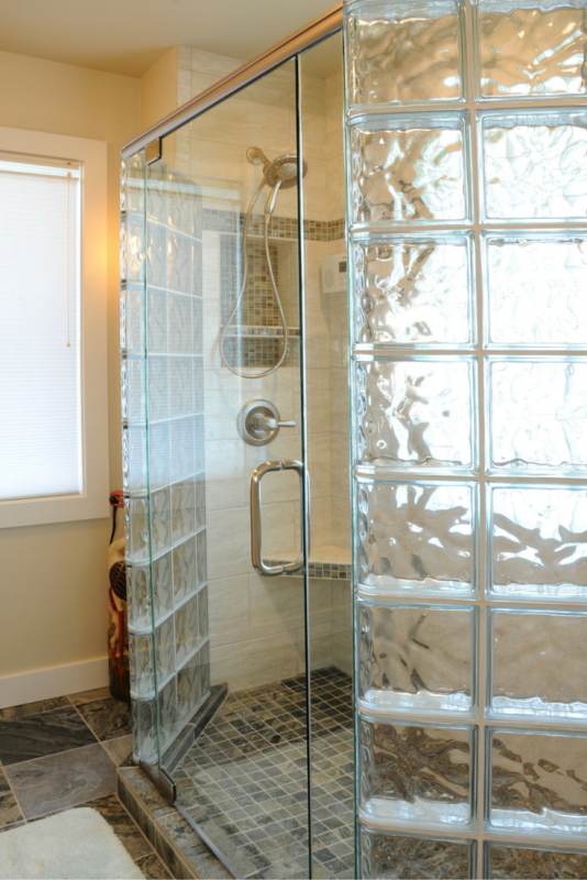 A glass block shower with a frameless glass door 