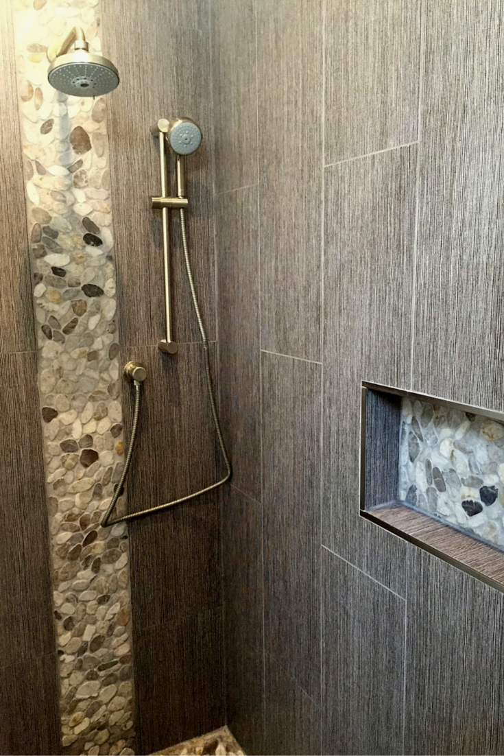 Zen minimalist shower with earth tone and pebble tile walls and floor