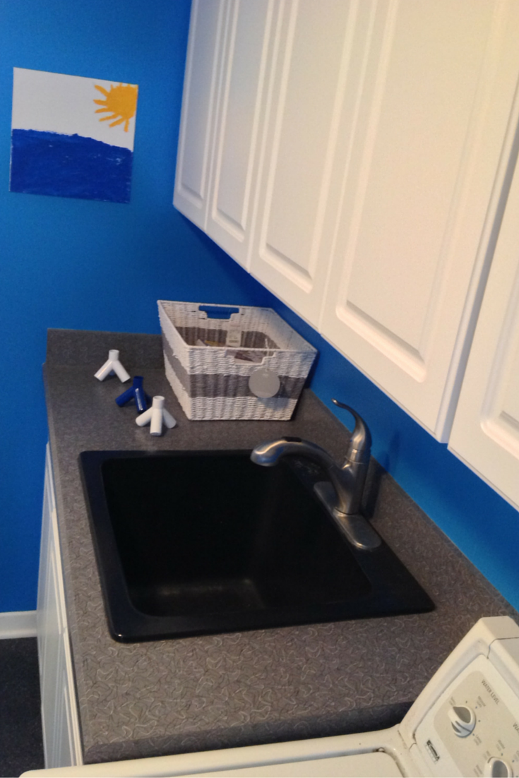 Laundry room with a retro laminate countertop and white raised panel cabinet doors 