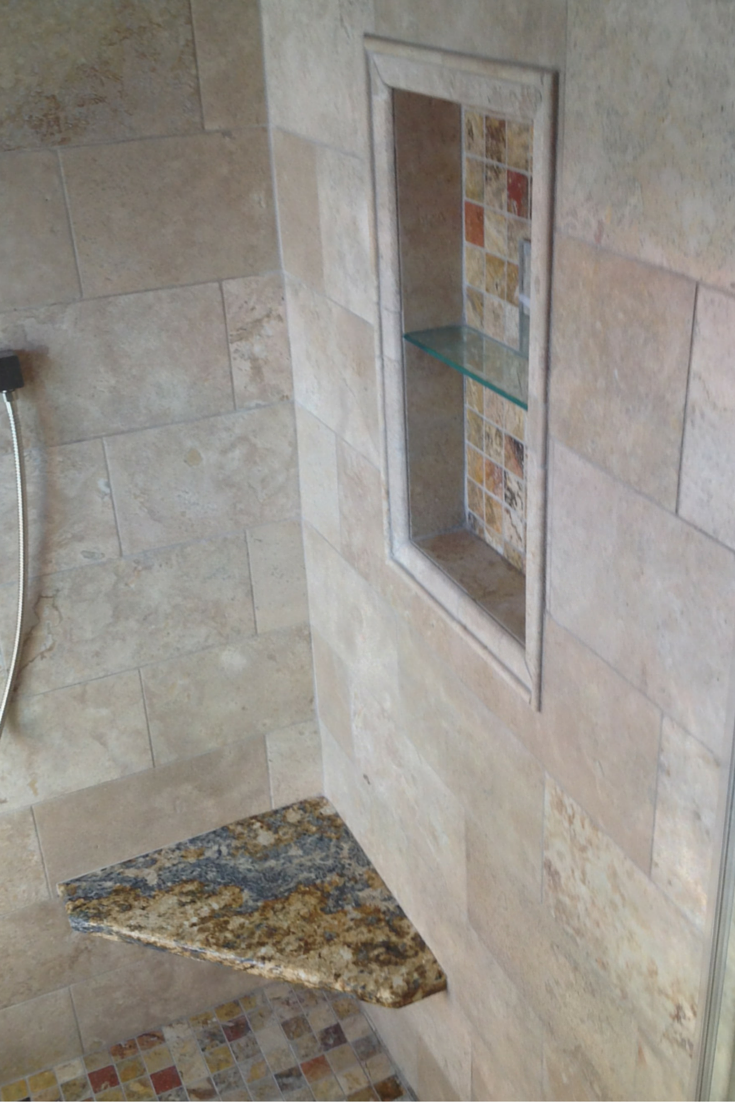 A Santa Cecilia Granite Shower bench seat adds light and color to a small columbus bathroom