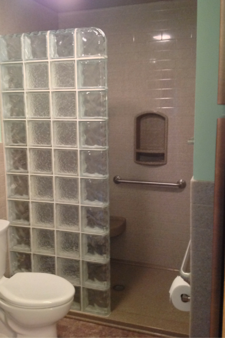 glass block walk in shower in an akron bathroom remodeling with a low profile solid surface base