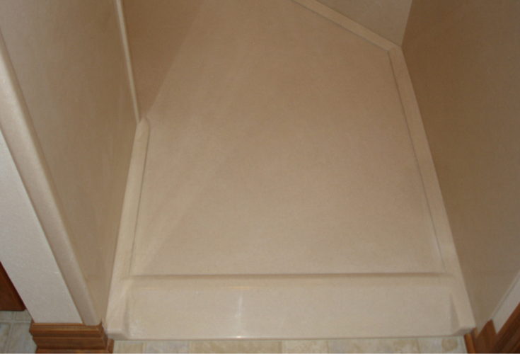 Solid surface shower pan with a ramped entry