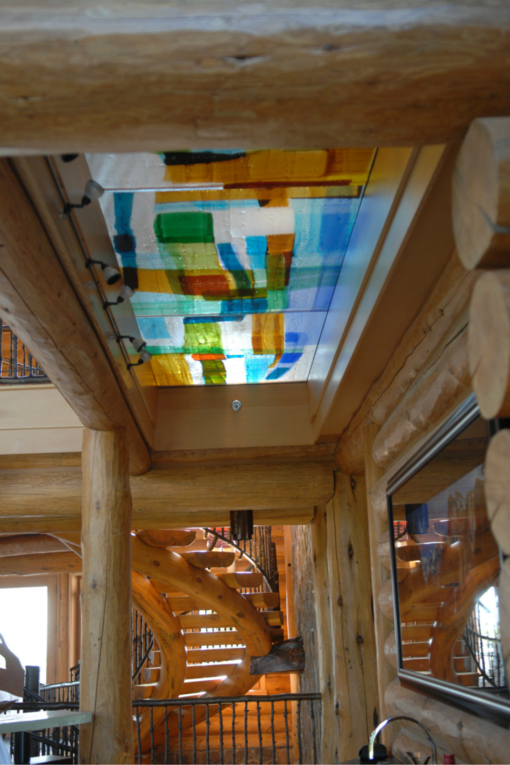 Colored art glass bridge in a log home interior 