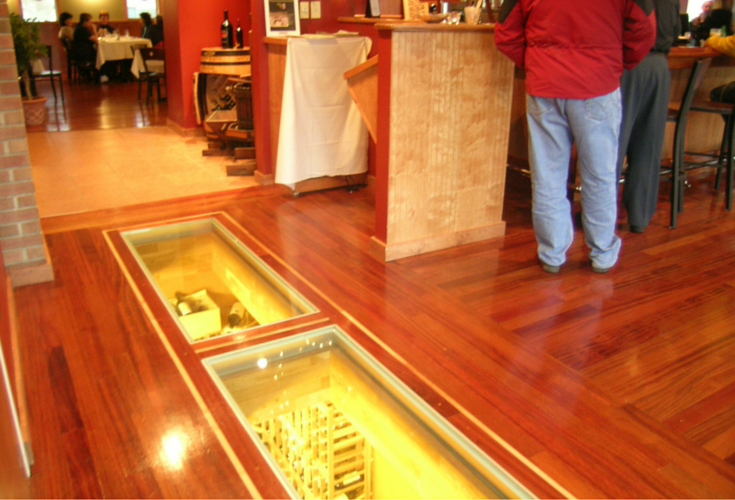 See through glass flooring in a restaurant with a wine cellar below 