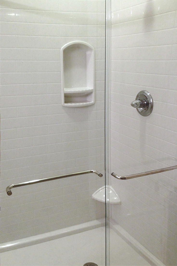 Sliding glass enclosure with a solid surface shower pan and wall panels 