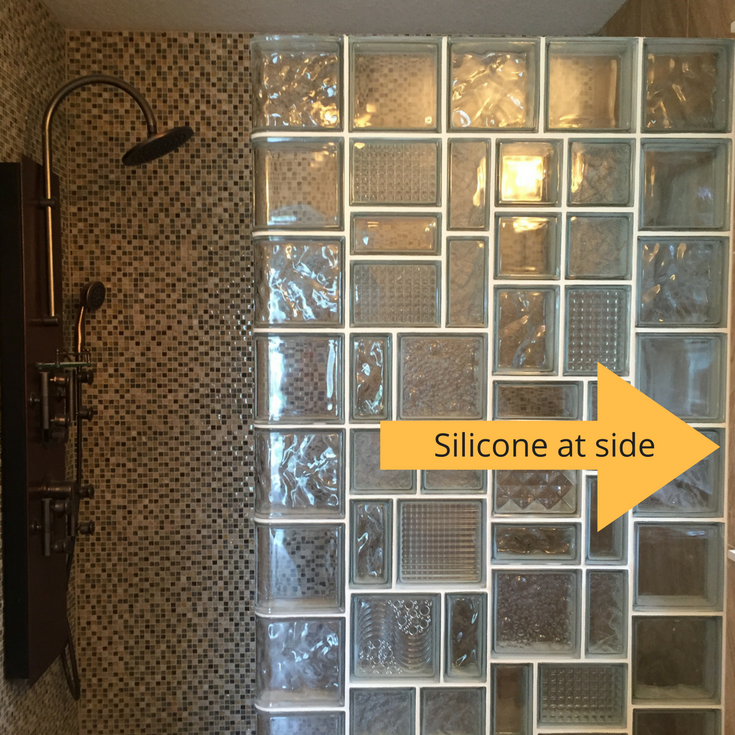 use silicone or grout caulk at the side of a glass block shower wall