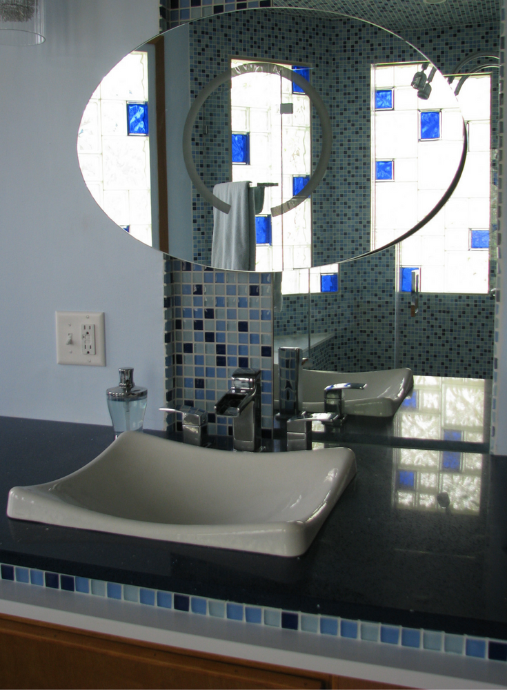 Mirrored reflection of a clear and colored glass block window in a contemporary bathroom | Innovate Building Solutions