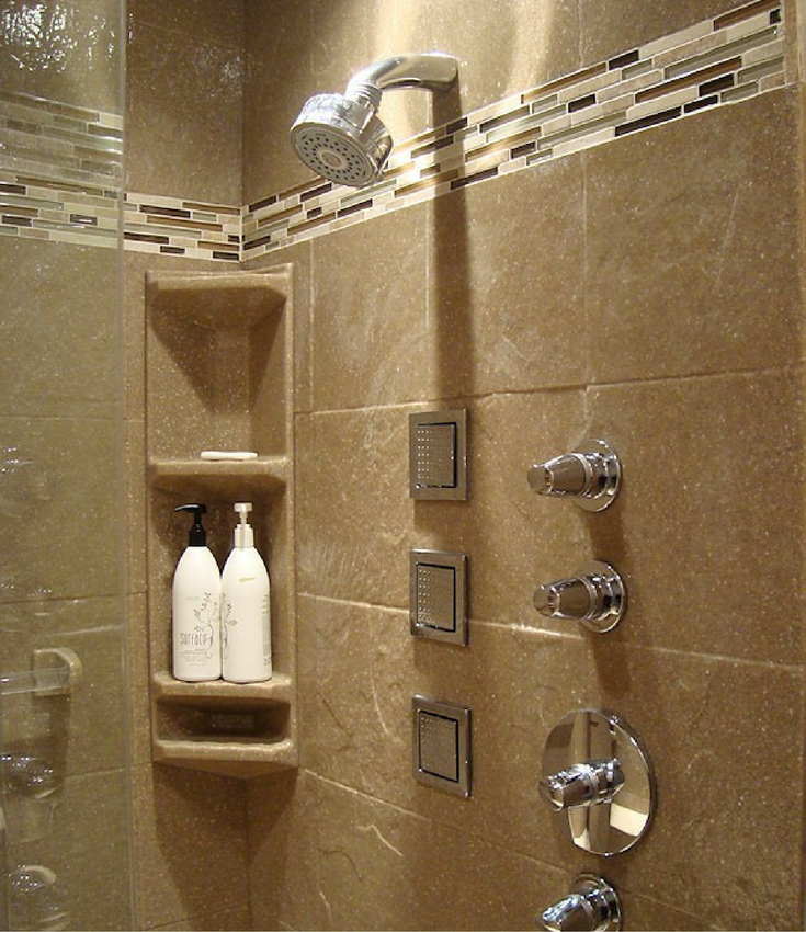 This solid surface shower wall panel system has a tall corner caddy a glass tile border. 