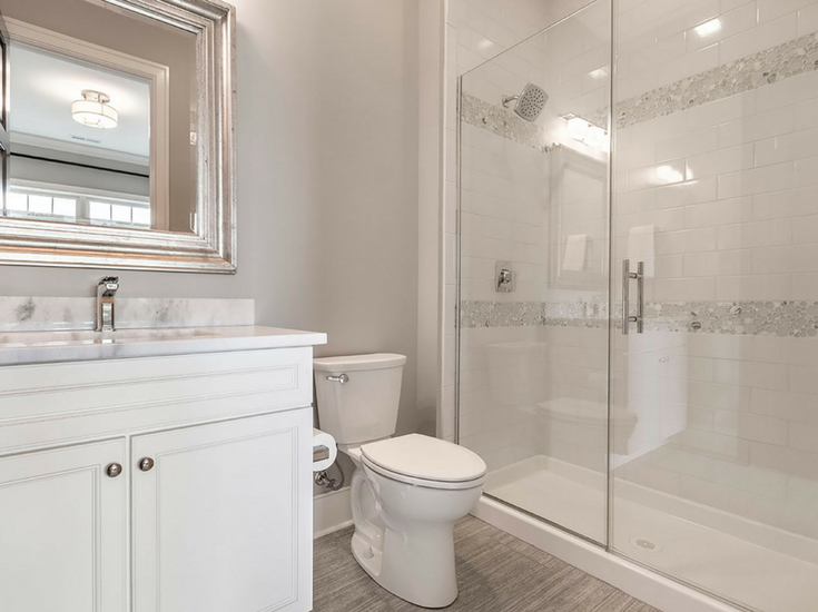 A circular glass tile pattern in a white subway tile upscale shower 