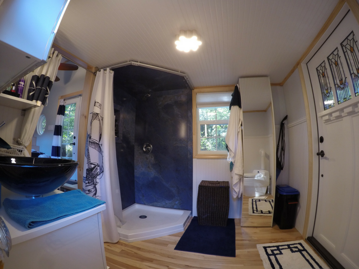 larger luxury bathroom with decorative shower wall panels in a custom tiny home in north carolina 