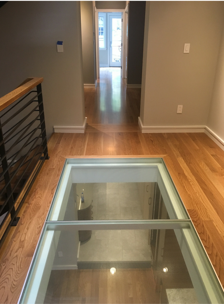 Pre-engineered glass flooring system with an aluminum grid around the perimeter of the glass 