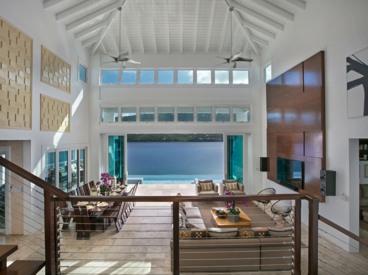 This contemporary entrance of this St. Thomas vacation home on Magen's Bay has a 45' tall ceiling with a view of an infinity pool and the bay beyond that. Innovate Building Solutions 