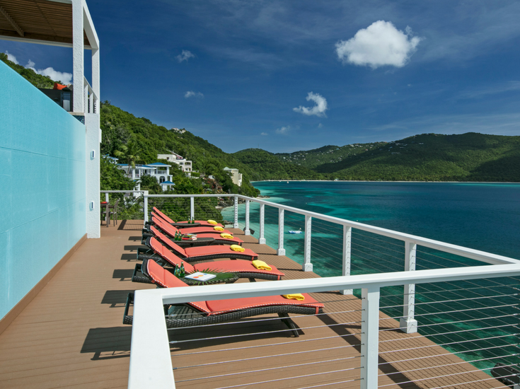 Light blue colored 36" x 36" glass panels on the side of an infinity pool at a St. Thomas vacation Home from Innovate Building Solutions