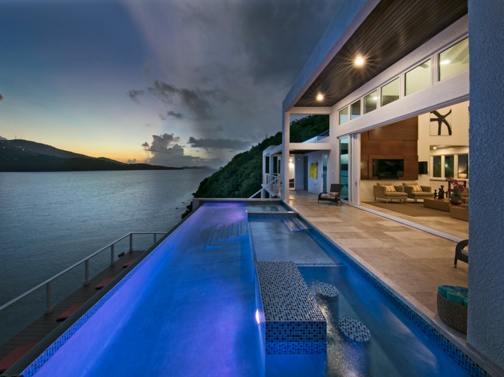 Nightime view of an infinity pool with LED lighting at a contemporary St. Thomas vacation home overlooking Magen's Bay - Innovate Building Solutions 