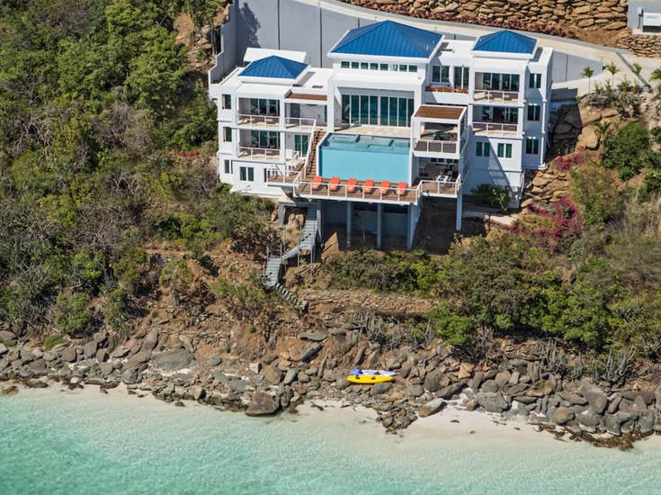 These 36" x 36" pieces of light blue back painted glass create a reflective surface on the side of this infinity pool wall which can be seen from miles away in this aerial view. Innovate Building Solutions 