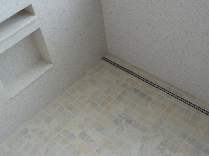 A linear drain system in a roll in shower floor pan | Innovate Building Solutions 