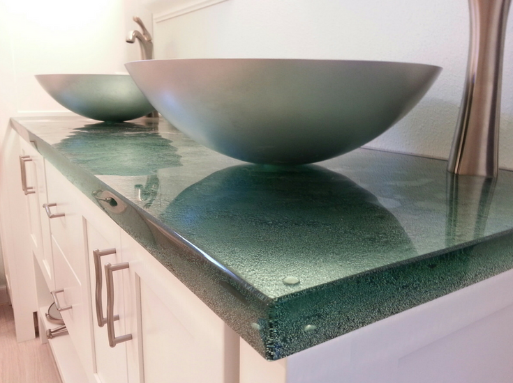 A cast glass vanity countertop in a contemporary bathroom with white shaker cabinetry | Innovate Building Solutions