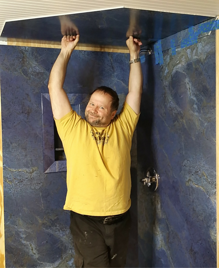 Raul Bajuski of The Tiny House Escape installing faux marble grout free shower wall panels. This is a top 10 blog post of 2016 from The Innovate Building Solutions remodeling blog. 