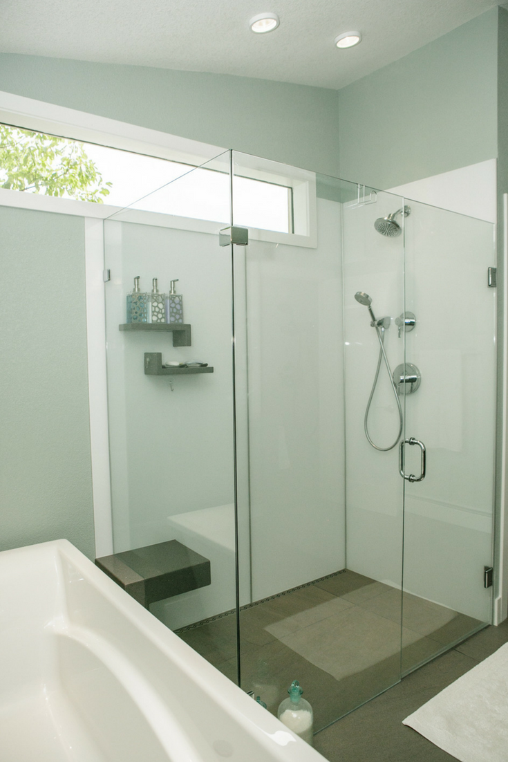 A contemporary high gloss shower wall panels system in an upscale bathroom remodeling project with a clear frameless glass enclosure system | Innovate Building Solutions