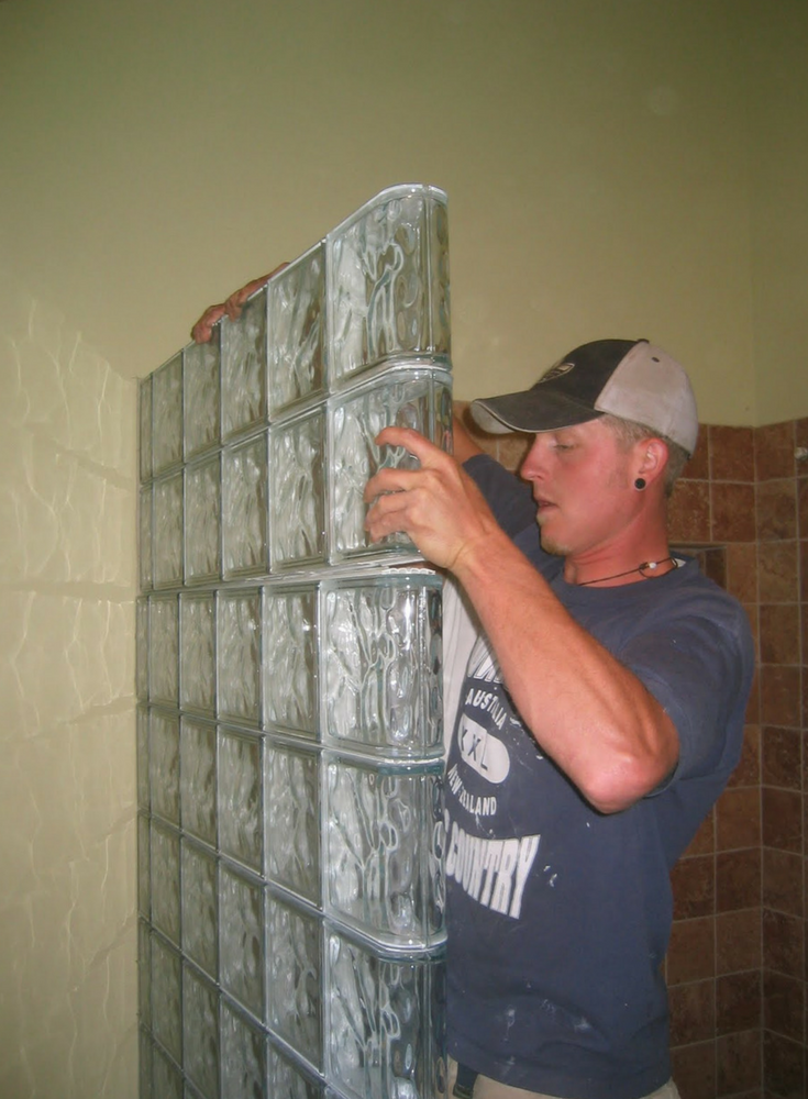 A glass block shower wall being installed with prefabricated sections which fit together like "Lego" blocks | Innovate Building Solutions