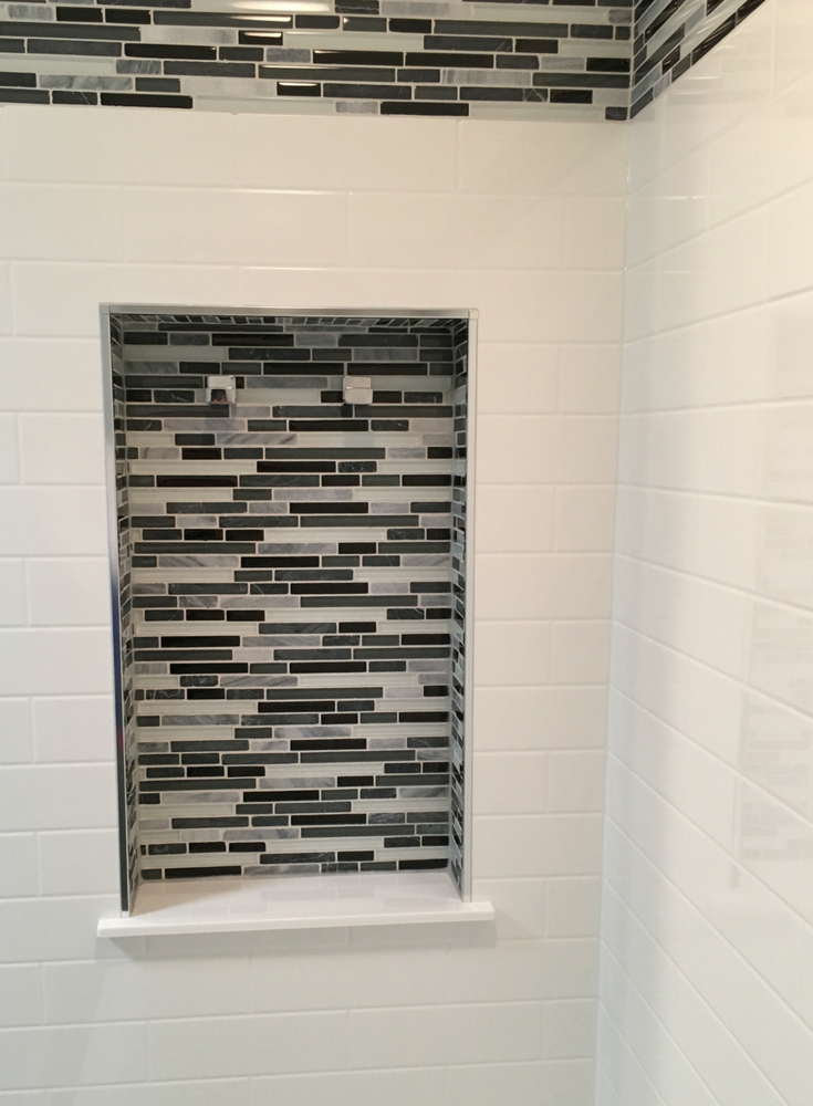 Tile shower niche inside of a solid surface subway tile shower wall surrounds | Innovate Building Solutions 