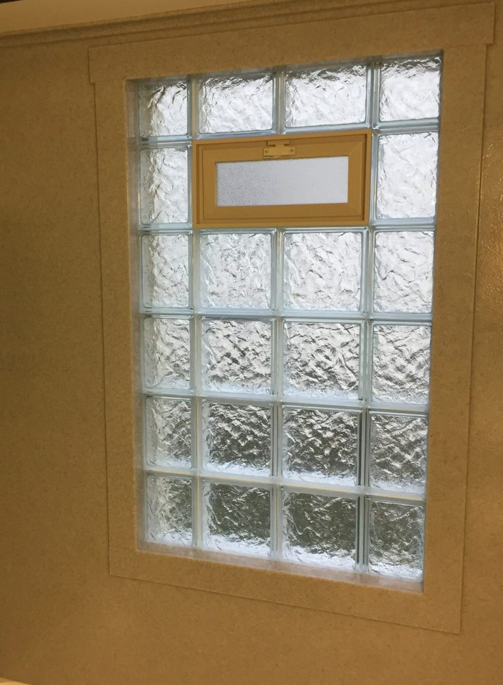 Solid surface window shower trim around a glass block vented window | Innovate Building Solutions 