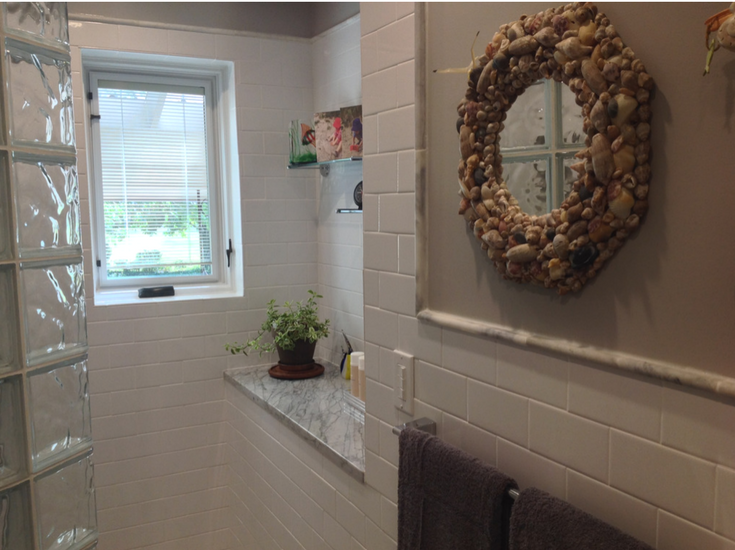 Vinyl framed shower window with integral blinds in a white subway tile shower | Innovate Building Solutions 