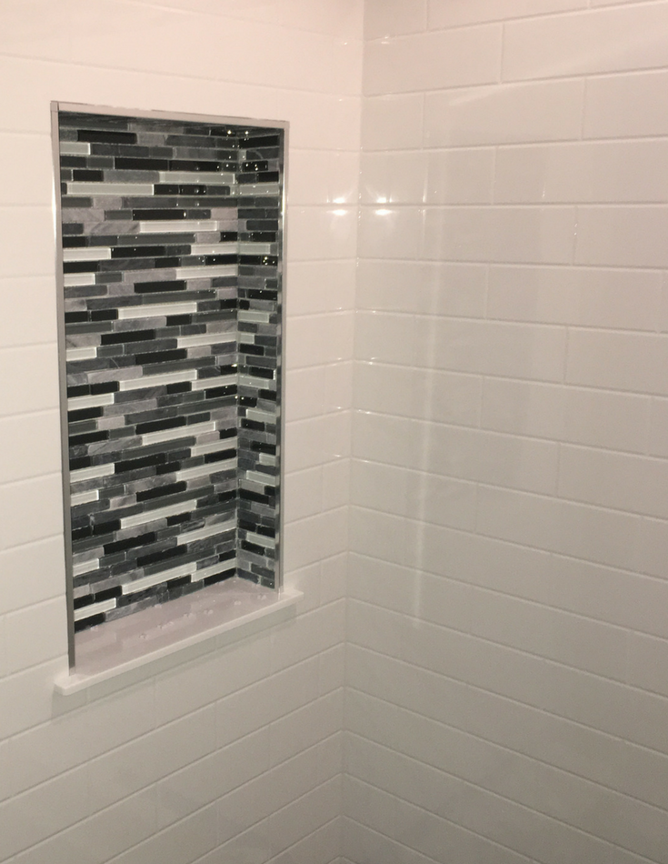 Solid surface grout free shower panels and glass tile recessed niche | Innovate Building Solutions