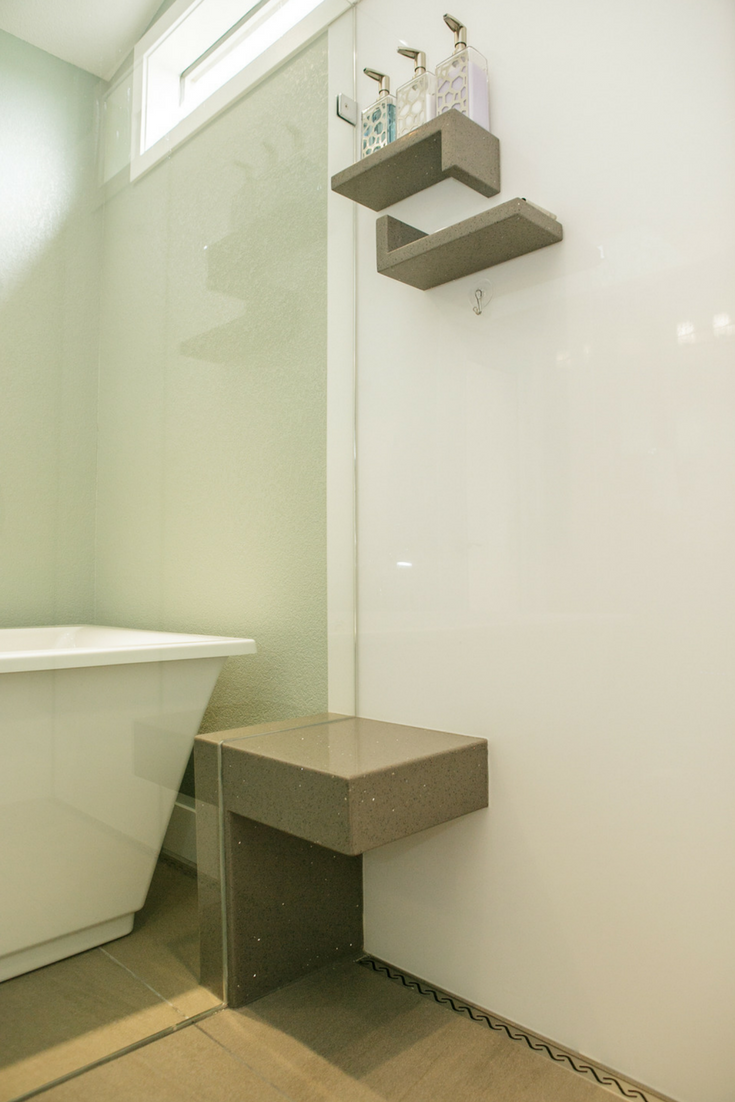 Contemporary luxury high gloss shower wall panels in a modern bathroom with a custom bench seat which extends outside the frameless glass enclosure | Innovate Building Solutions 