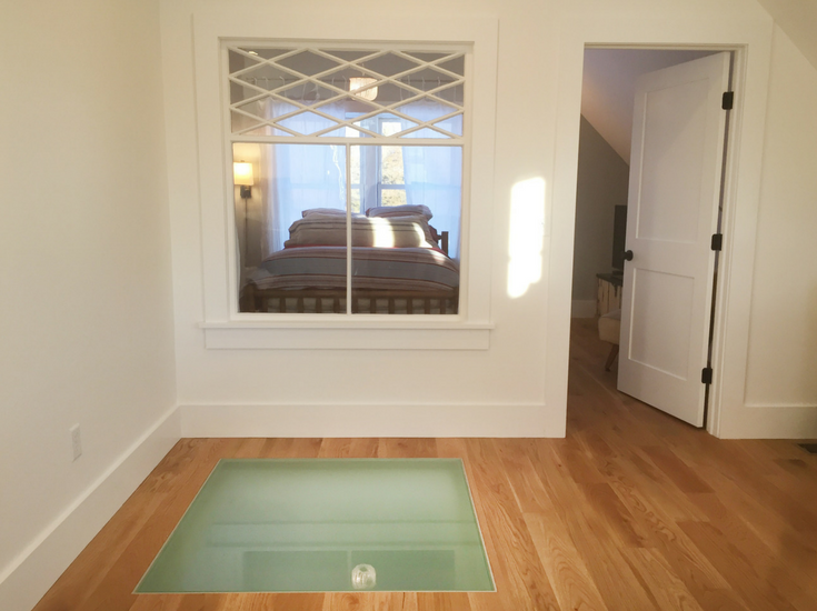 Obscure glass floor panel system in a lofted studio in a modern custom farmhouse moves light into the kitchen below | Innovate Building Solutions 