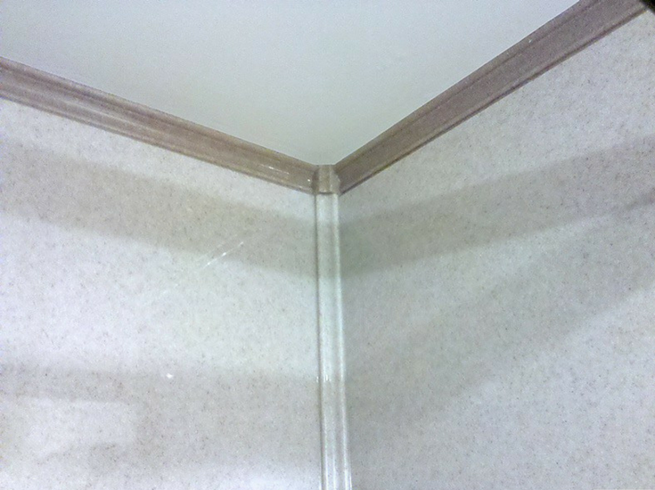 Corner trim and crown molding in a solid surface shower | Innovate Building Solutions