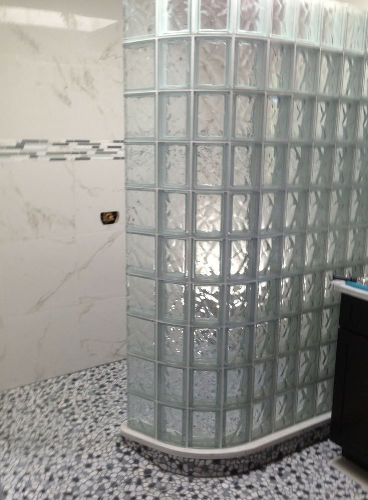 Curved glass block shower wall in a wave pattern with a premade waterproof ready for tile shower base | Innovate Building Solutions 